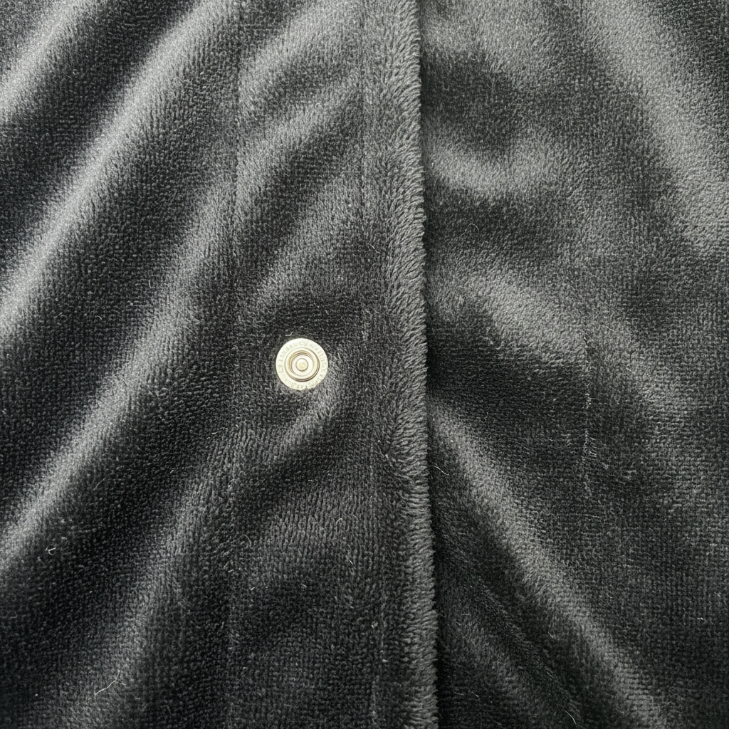 Black fabric snap button detail on white background