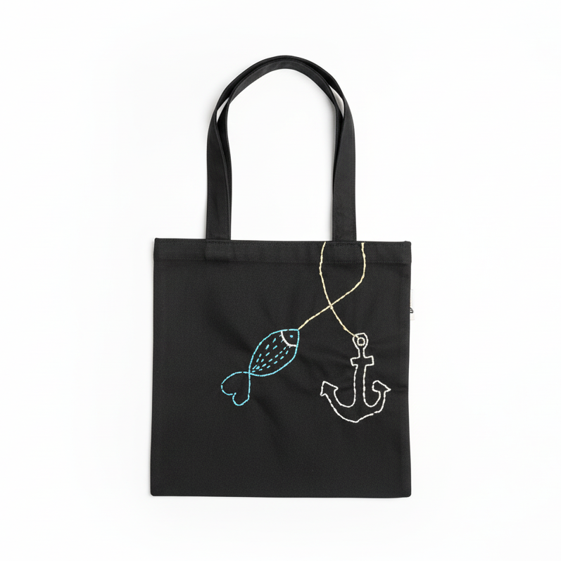 Black tote bag with fish and anchor design on white background