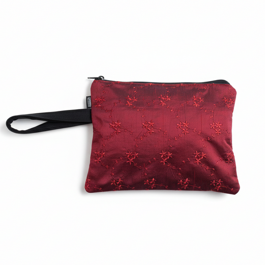 Burgundy red embroidered wristlet clutch on white background