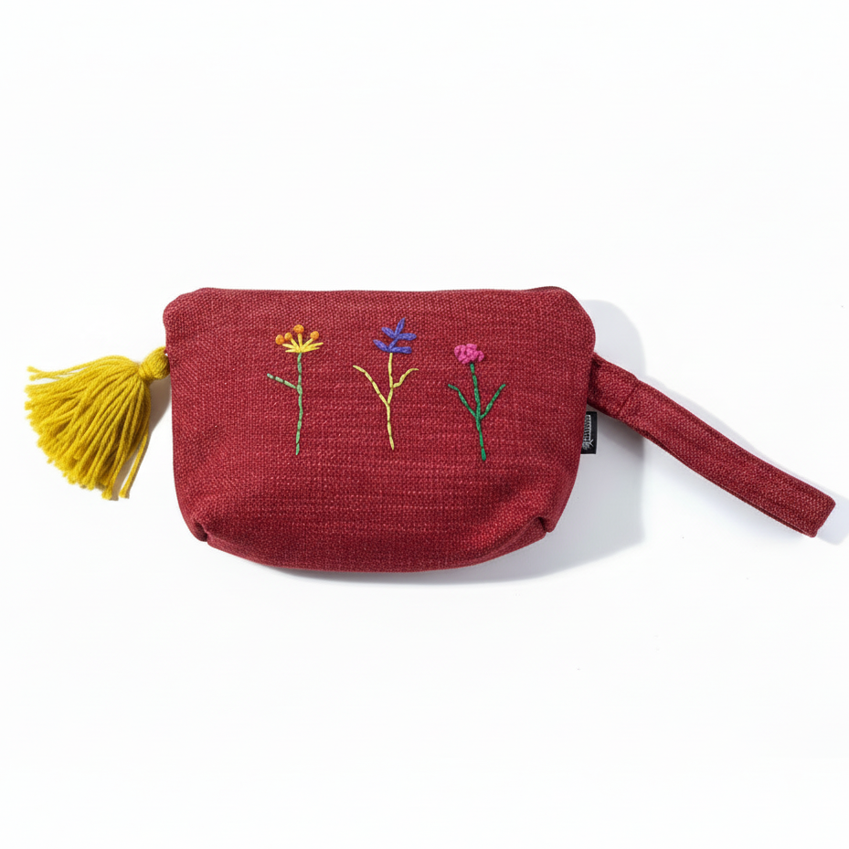 Burgundy red embroidered wristlet clutch with yellow tassel on white background
