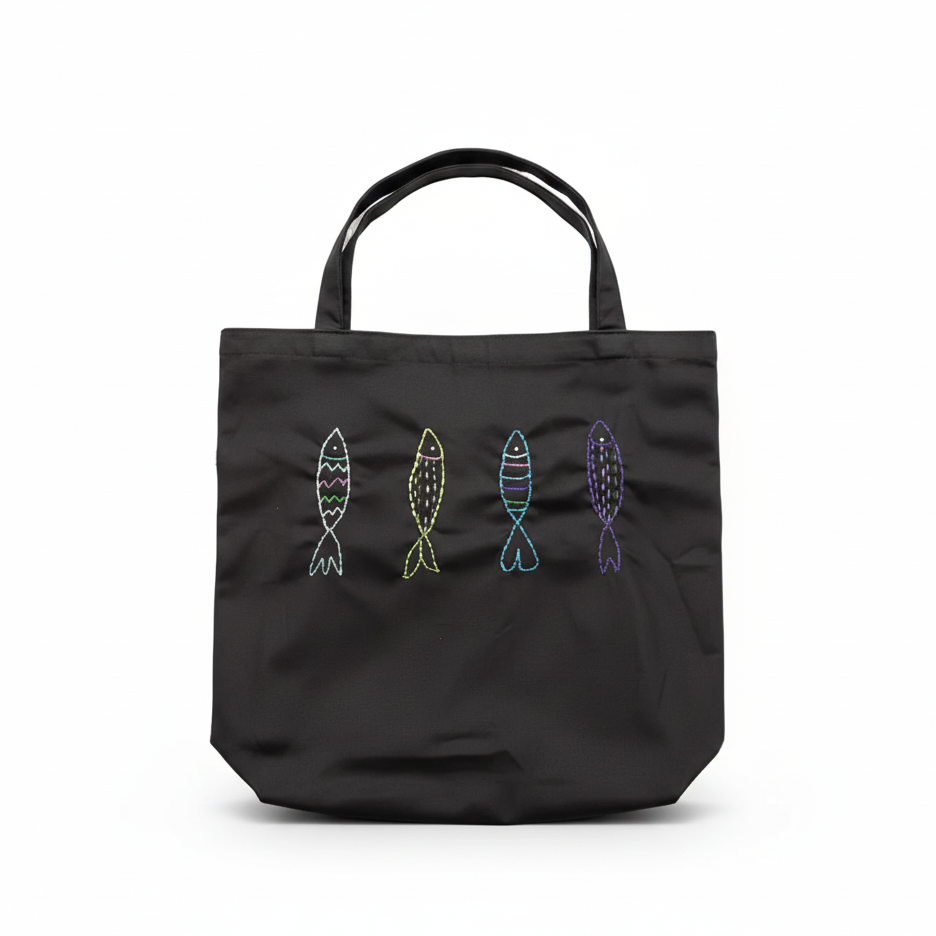 Charcoal gray canvas tote bag with embroidered fish on white background