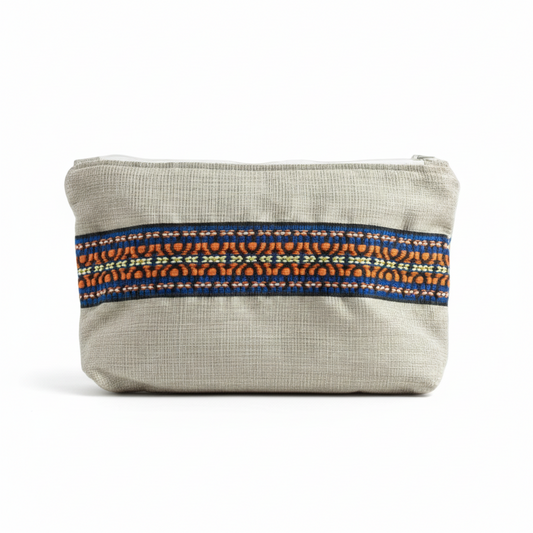 Cream beige woven clutch with blue and orange embroidered trim on white background