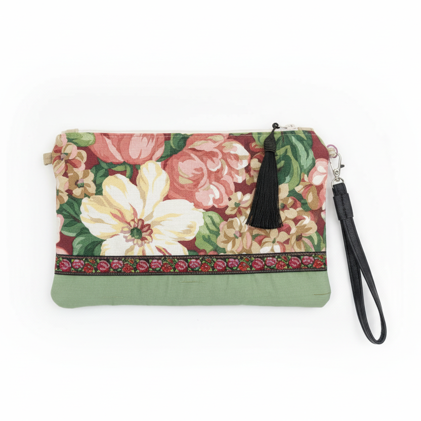 Floral print wristlet clutch with sage green panel on white background