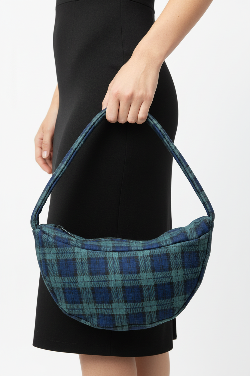 Hand holding navy blue and teal plaid bag