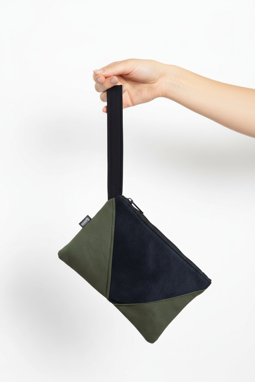 Hand holding two-tone wristlet clutch