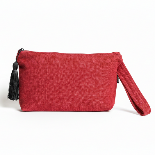 Red textured woven wristlet clutch with black tassel on white background