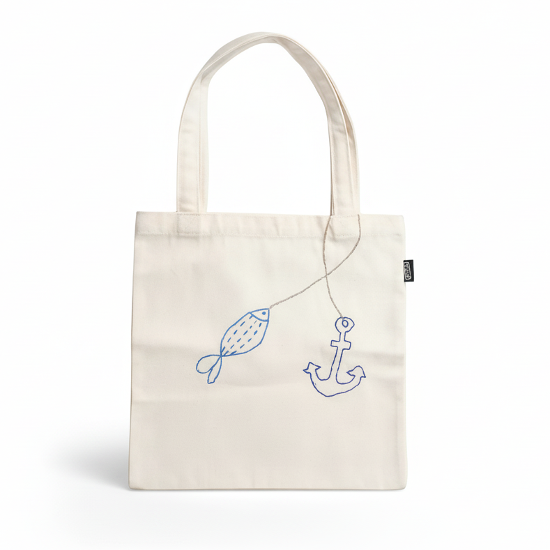 White tote bag with fish and anchor design on white background